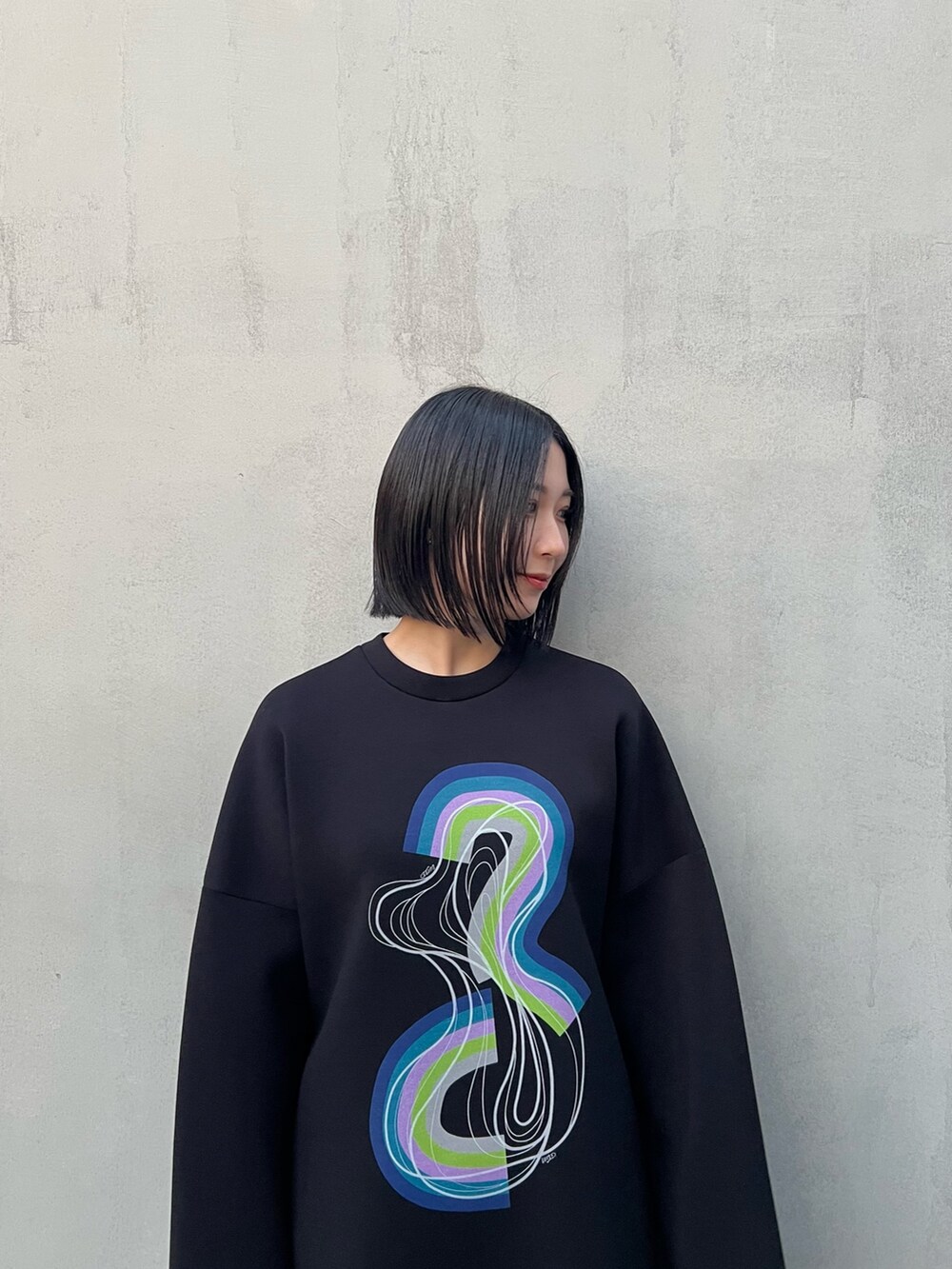 ブラック系のTシャツ/カットソー、グレー系のスカート、ブラック系のブーツを着用したレディースの冬コーディネートの4枚目の写真
