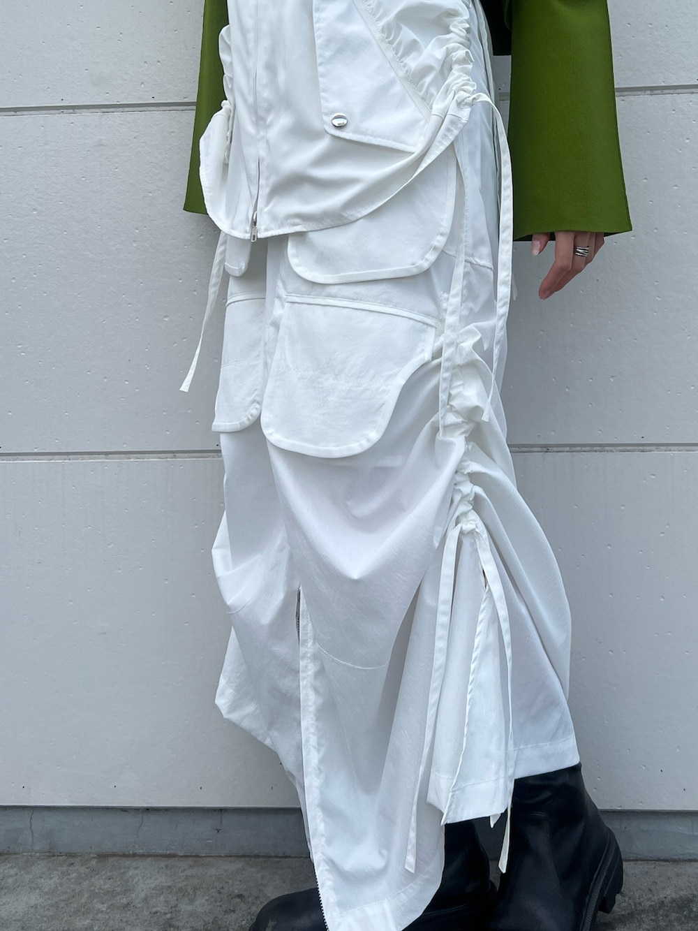 ホワイト系のスカート、グリーン系のニット/セーター、ブラック系のショルダーバッグを着用したレディースの冬コーディネートの5枚目の写真