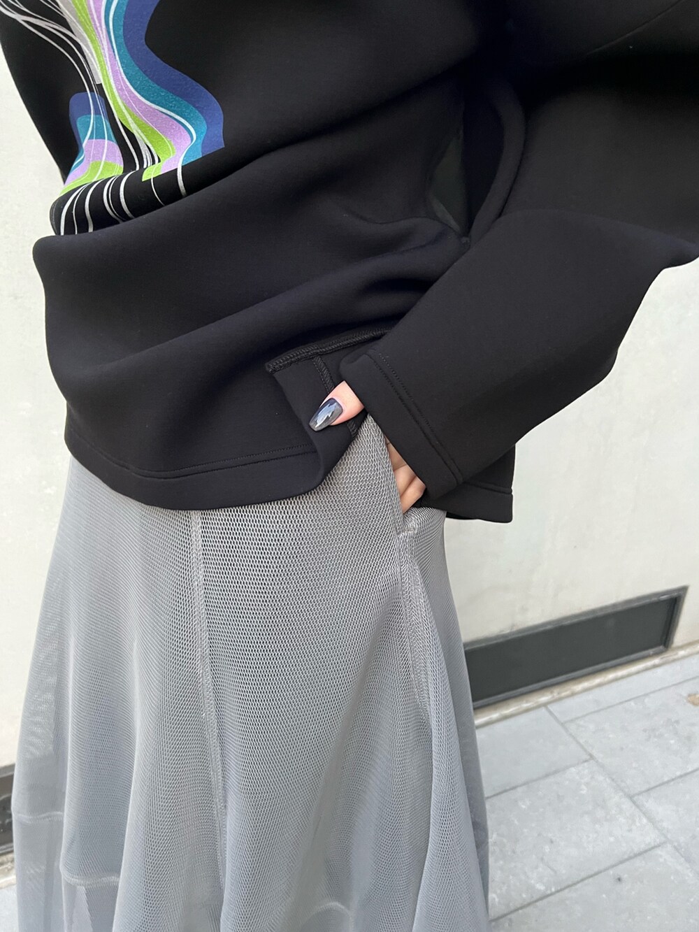 ブラック系のTシャツ/カットソー、グレー系のスカート、ブラック系のブーツを着用したレディースの冬コーディネートの7枚目の写真