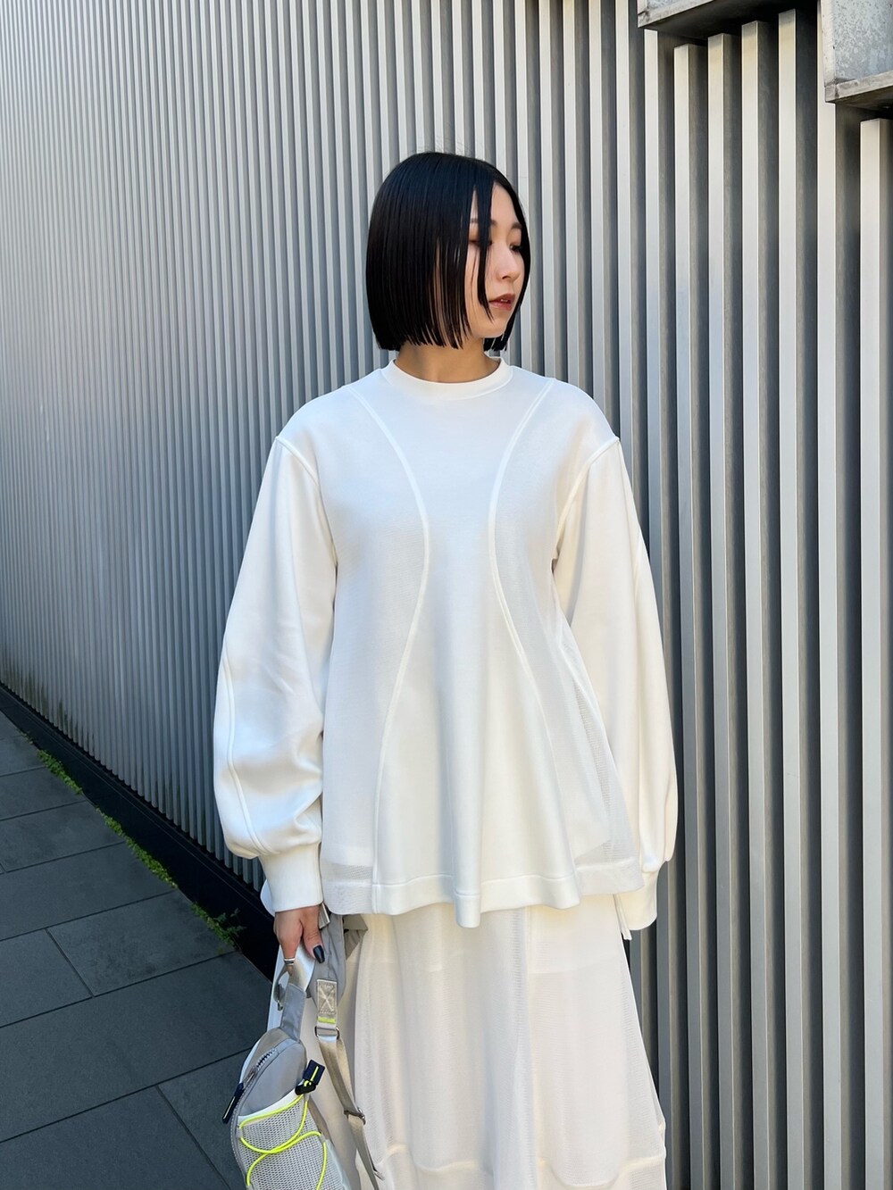 ベージュ系のボディバッグ/ウエストポーチ、ホワイト系のTシャツ/カットソー、ホワイト系のスカートを着用したレディースの冬コーディネートの3枚目の写真