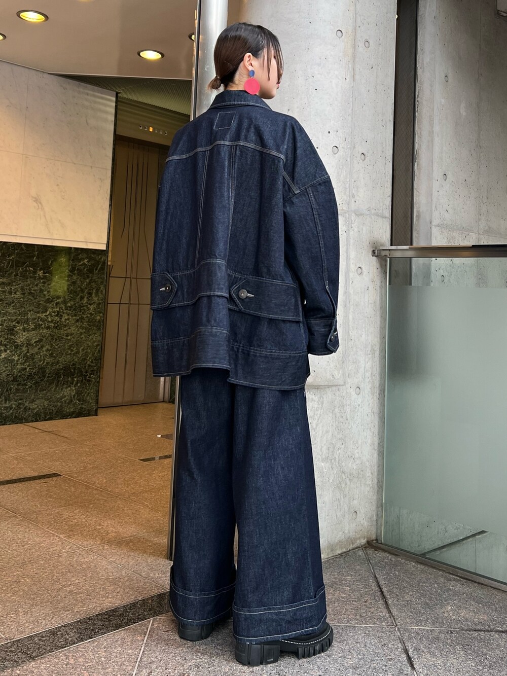 ブルー系のデニムパンツ、ブルー系のデニムジャケット、ブラック系のブーツを着用したレディースの冬コーディネートの3枚目の写真