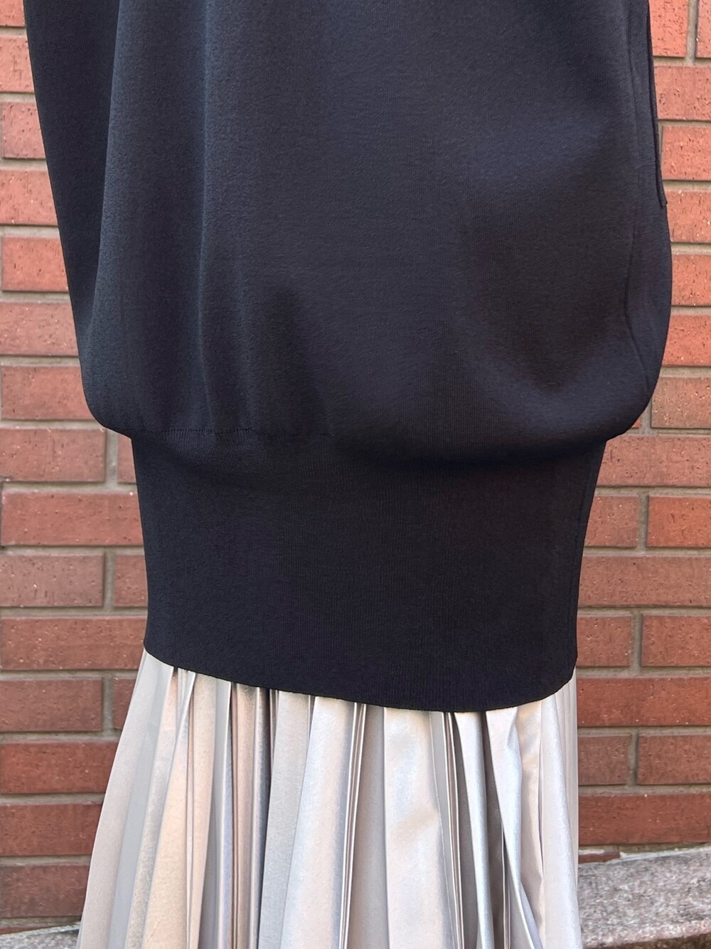 ブラック系のカーディガン/ボレロ、グレー系のニット/セーター、シルバー系のスカートを着用したレディースの秋コーディネートの5枚目の写真