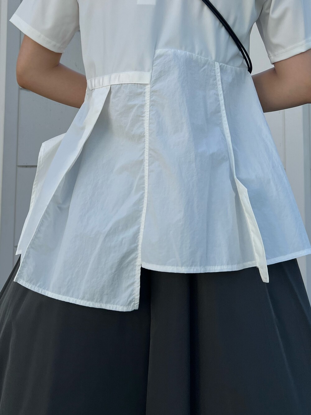 ホワイト系のTシャツ/カットソー、グレー系のその他パンツ、ブラック系のサンダルを着用したレディースの夏コーディネートの6枚目の写真