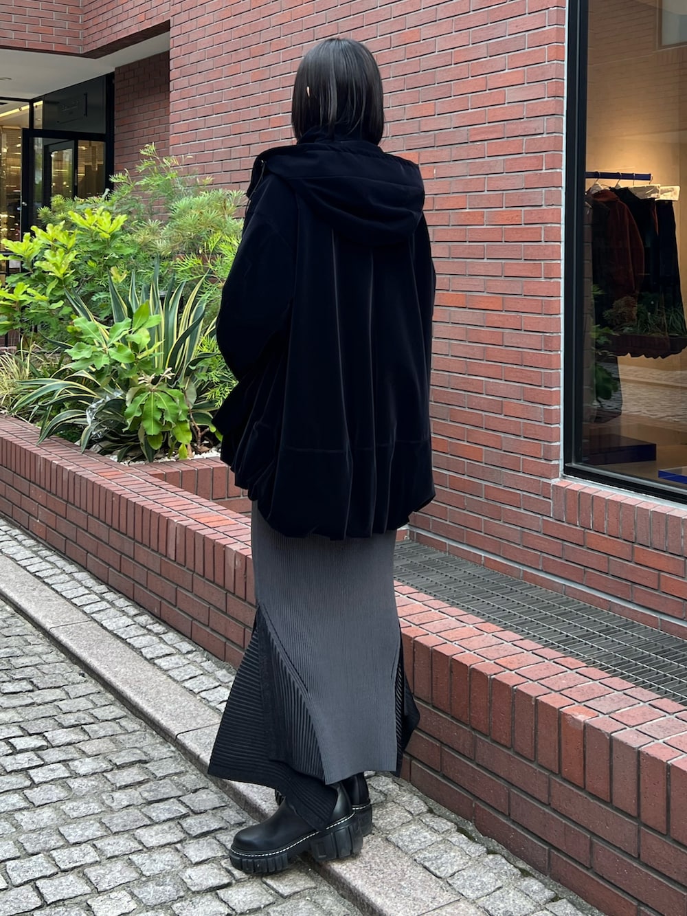 ブラック系のその他アウター、ブラック系のスカート、ブラック系のブーツを着用したレディースの秋コーディネートの3枚目の写真