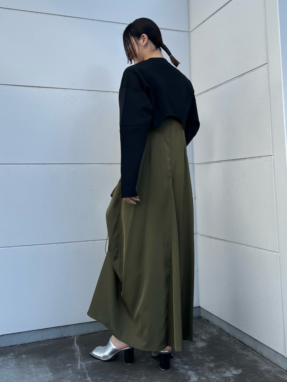 ブラック系のカーディガン/ボレロ、ベージュ系のワンピース、シルバー系のショルダーバッグを着用したレディースの春コーディネートの2枚目の写真