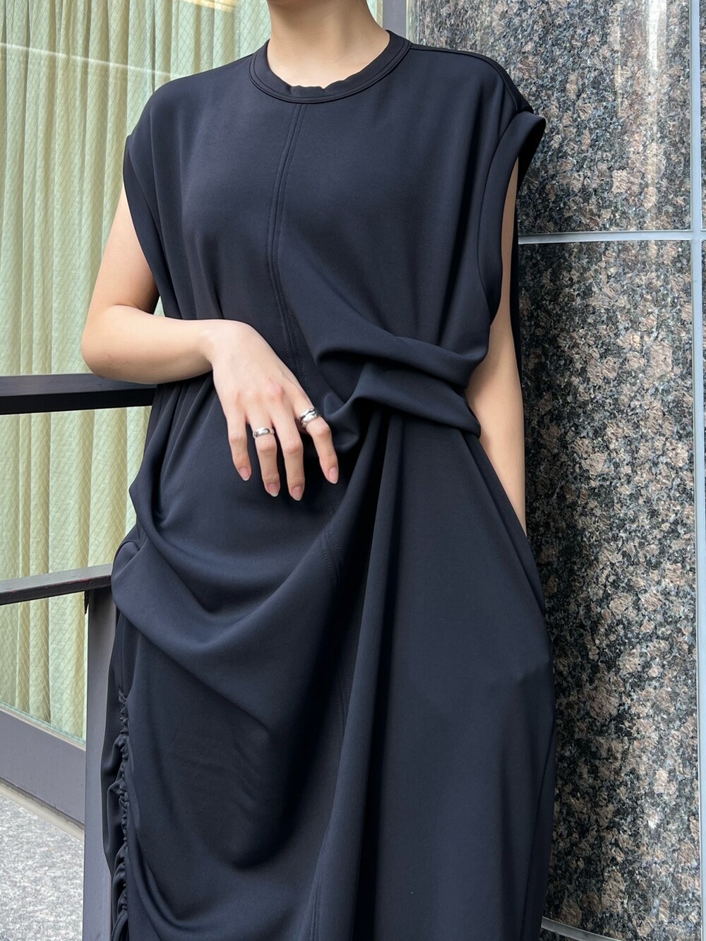 ブラック系のワンピース、ゴールド系のパンプス、ゴールド系のイヤリングを着用したレディースの冬コーディネートの3枚目の写真