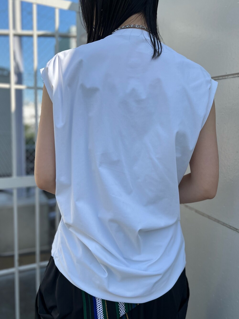 ホワイト系のTシャツ/カットソー、グリーン系のスカート、シルバー系のパンプスを着用したレディースの夏コーディネートの7枚目の写真