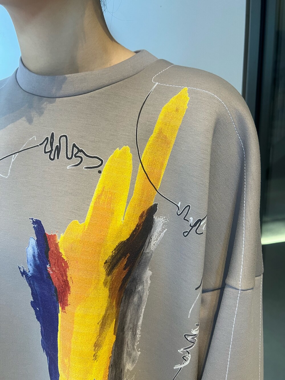 シルバー系のスカート、ベージュ系のTシャツ/カットソー、ブラック系のブーツを着用したレディースの冬コーディネートの4枚目の写真