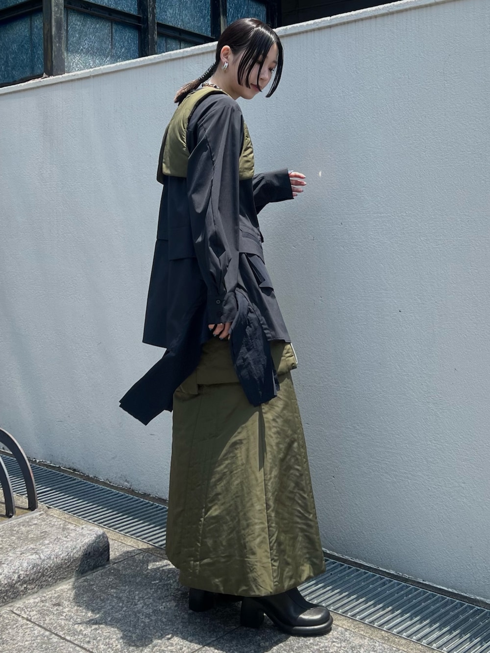 ベージュ系のスカート、ベージュ系のベスト、ブラック系のシャツ/ブラウスを着用したレディースの夏コーディネートの2枚目の写真