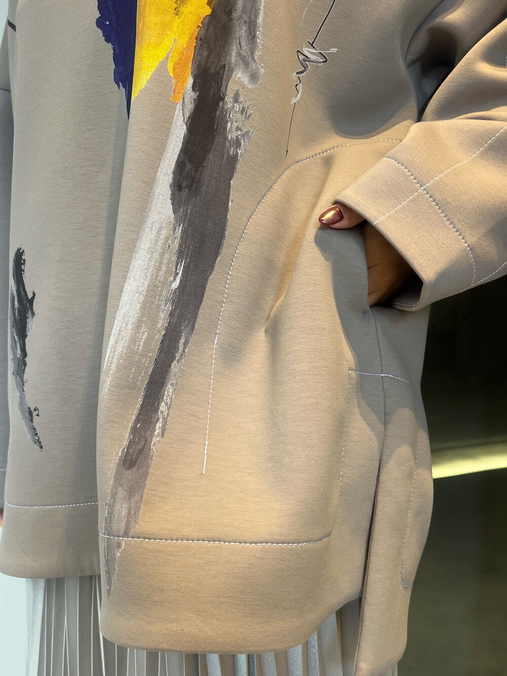 シルバー系のスカート、ベージュ系のTシャツ/カットソー、ブラック系のブーツを着用したレディースの冬コーディネートの5枚目の写真