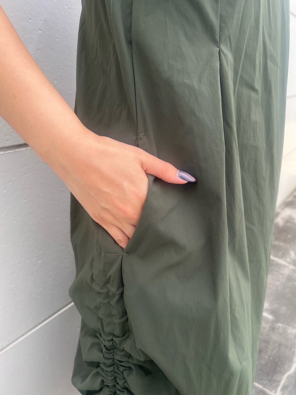 グリーン系のワンピース、ブラック系のトートバッグ、ブラック系のサンダルを着用したレディースの夏コーディネートの6枚目の写真