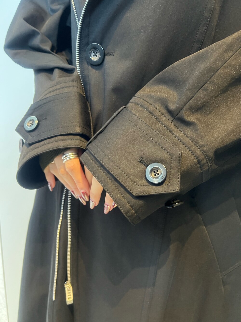 ブラック系のトレンチコート、ベージュ系のその他パンツ、ベージュ系のブーツを着用したレディースの冬コーディネートの6枚目の写真