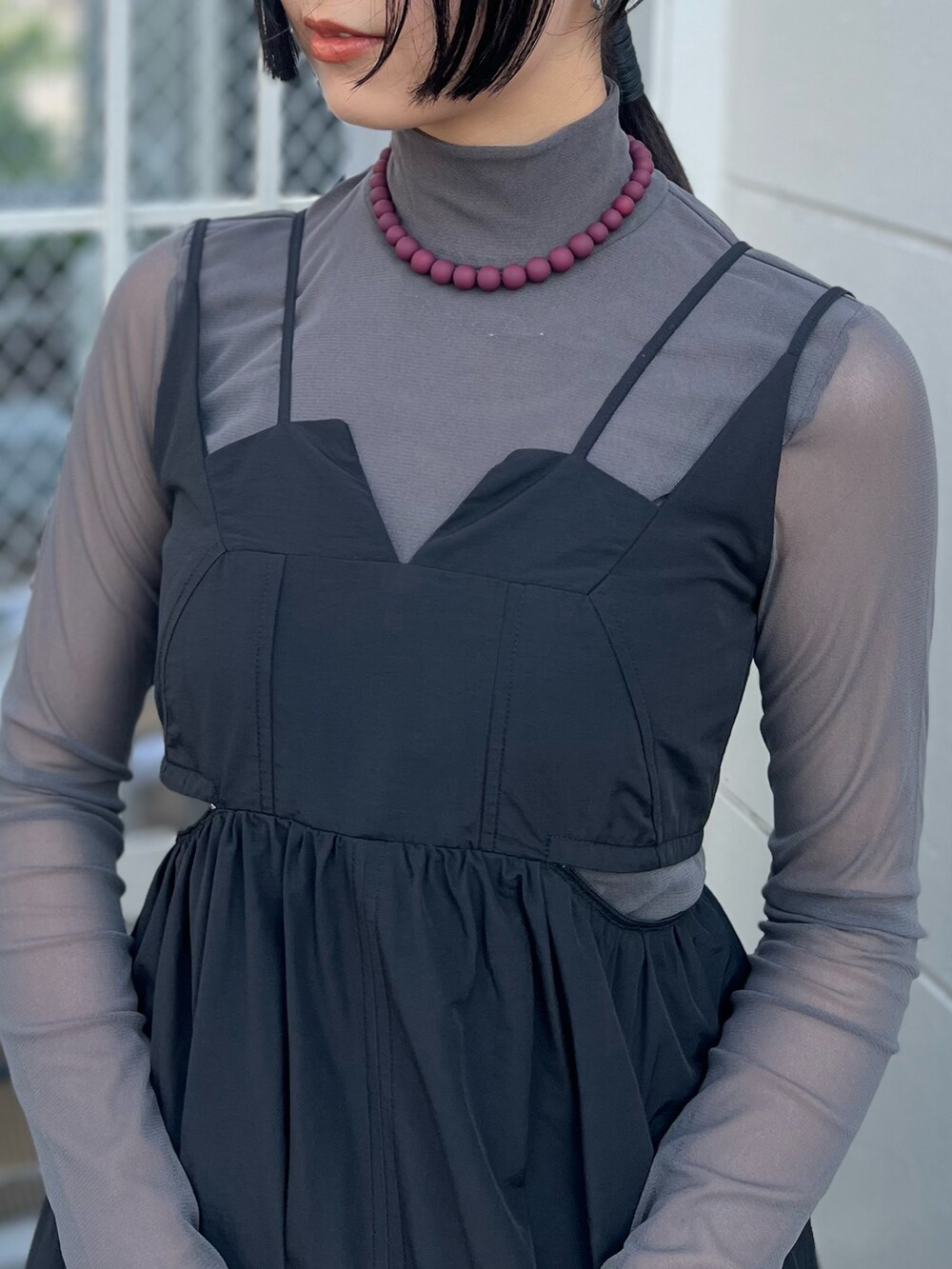 ブラック系のワンピース、グレー系のTシャツ/カットソー、シルバー系のハンドバッグを着用したレディースの夏コーディネートの3枚目の写真