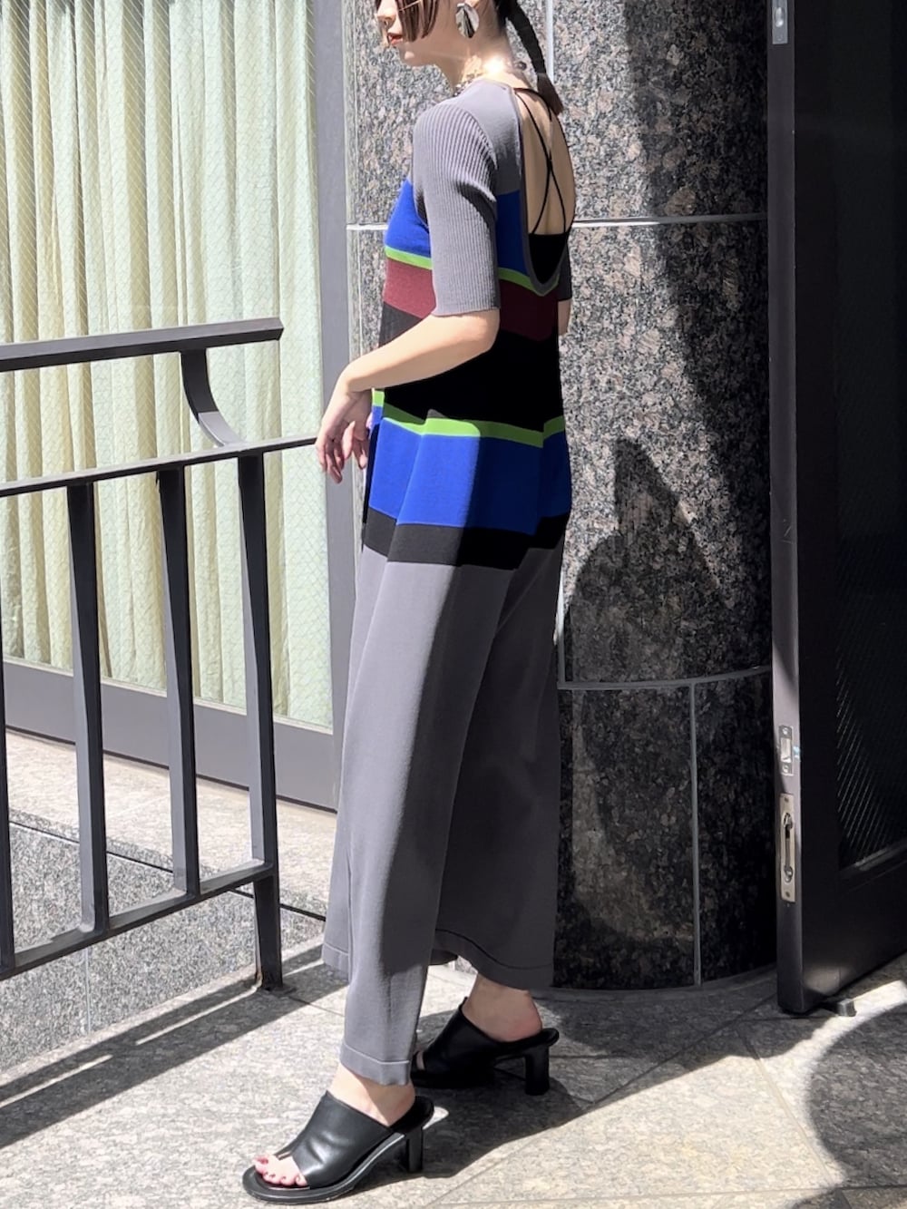 グレー系のワンピース、ブラック系のサンダル、シルバー系のネックレスを着用したレディースの春コーディネートの3枚目の写真