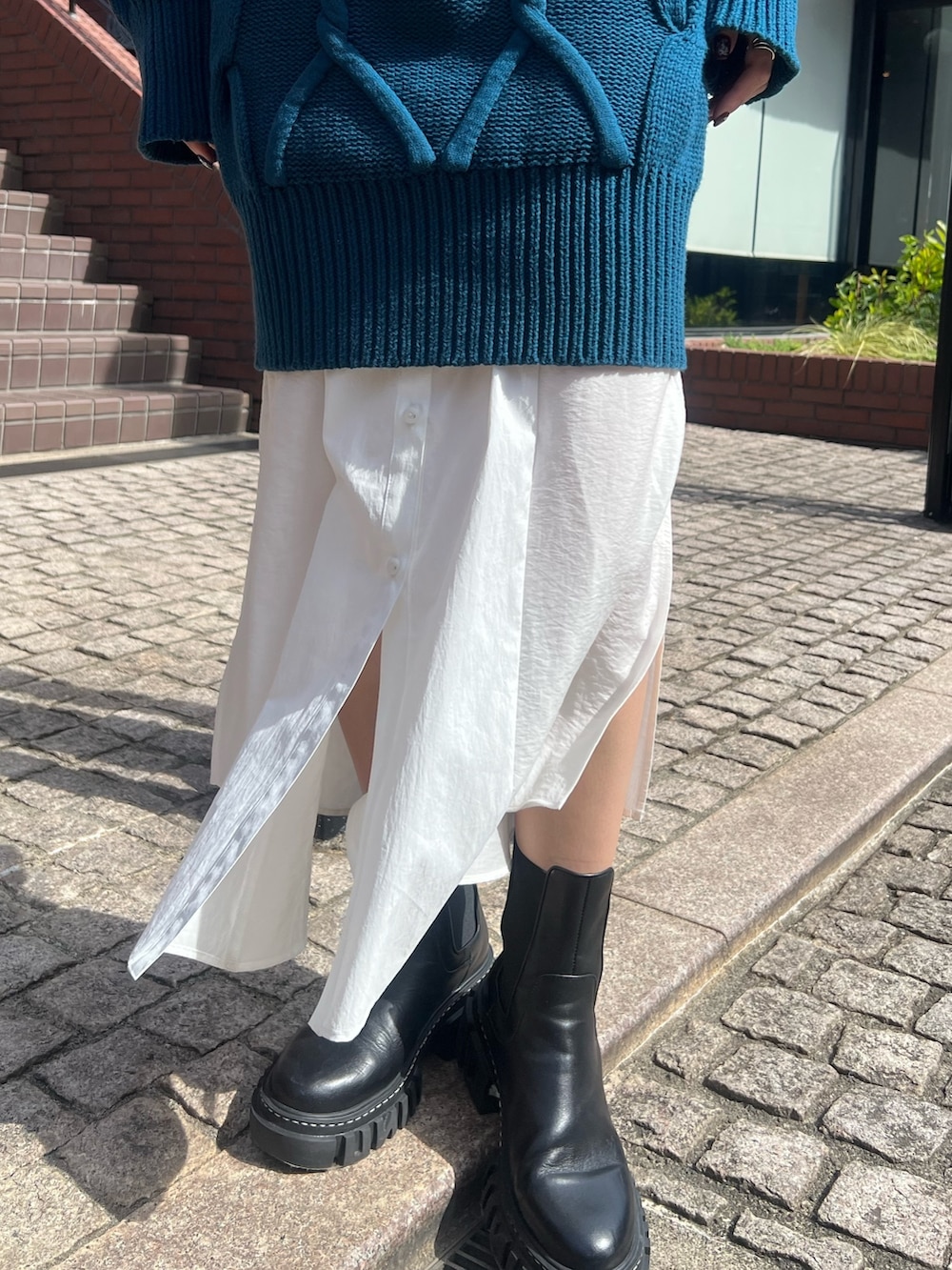 ブルー系のワンピース、ブラック系のブーツ、シルバー系のイヤリングを着用したレディースの秋コーディネートの5枚目の写真