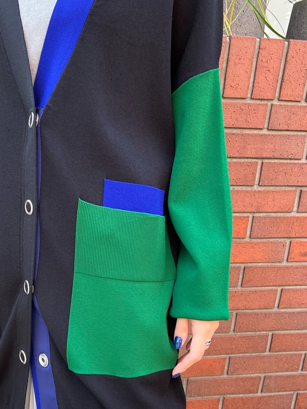 ブラック系のカーディガン/ボレロ、グレー系のニット/セーター、シルバー系のスカートを着用したレディースの秋コーディネートの7枚目の写真