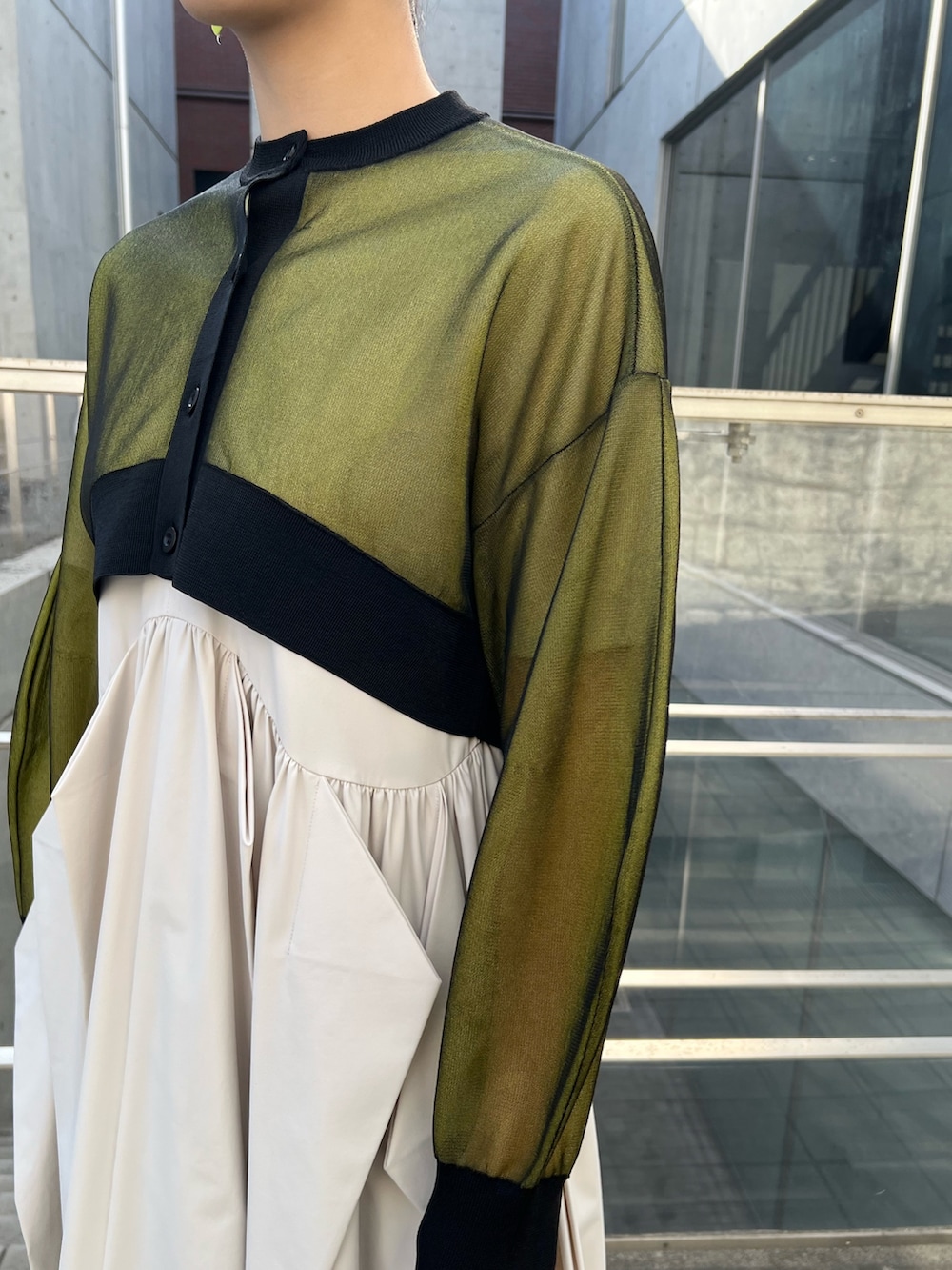 イエロー系のカーディガン/ボレロ、ベージュ系のワンピース、ブラック系のブーツを着用したレディースの冬コーディネートの7枚目の写真