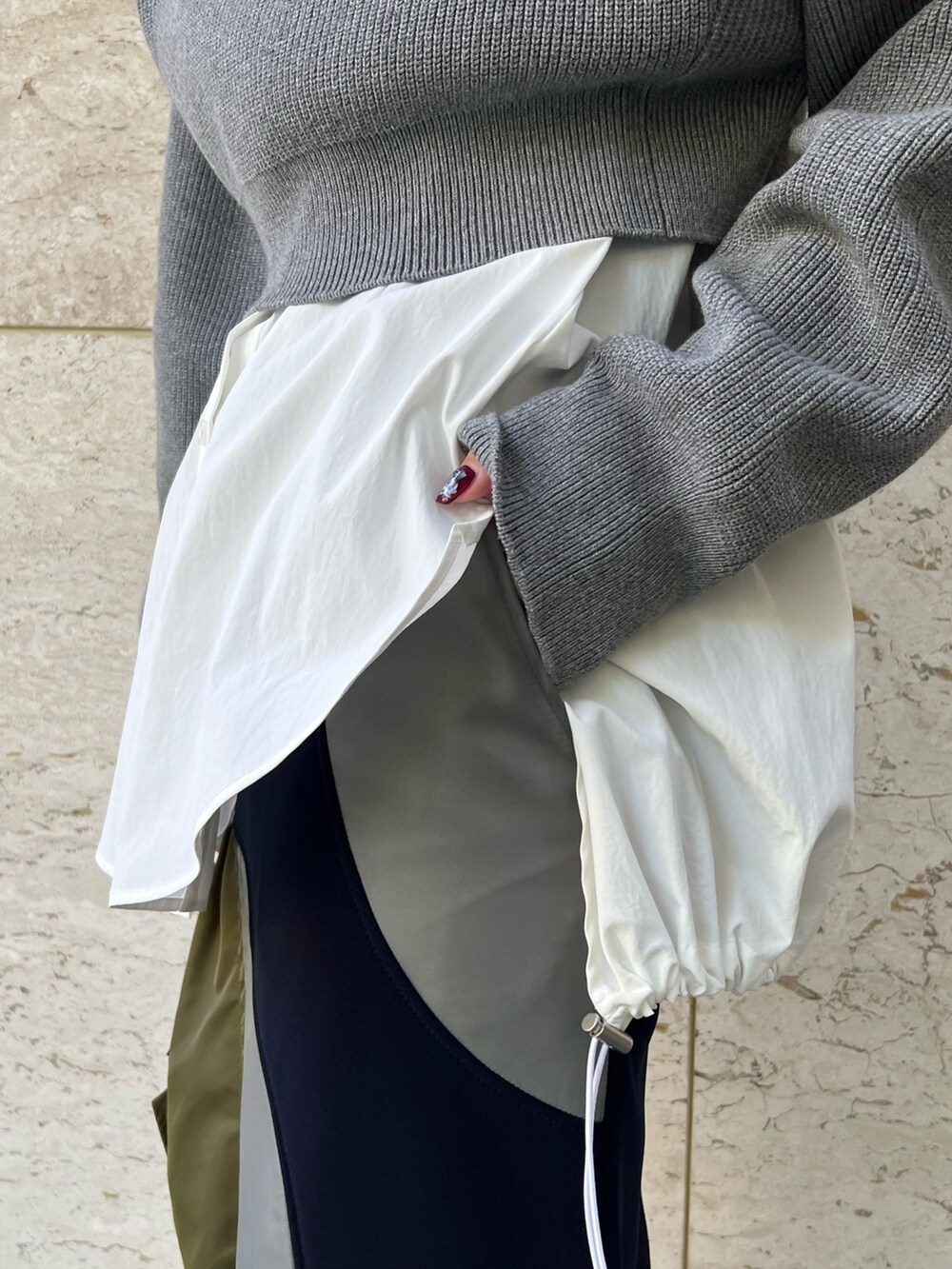 グレー系のニット/セーター、ホワイト系のシャツ/ブラウス、ブルー系のスカートを着用したレディースの秋コーディネートの5枚目の写真