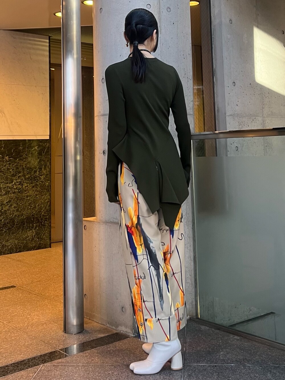 グリーン系のニット/セーター、ベージュ系のその他パンツ、ベージュ系のブーツを着用したレディースの冬コーディネートの2枚目の写真