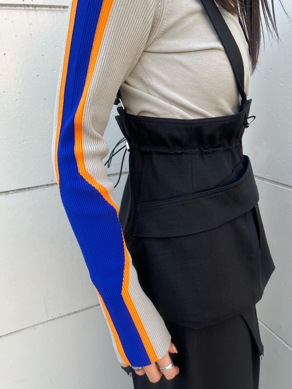 ベージュ系のニット/セーター、ブラック系のその他パンツ、シルバー系のブーツを着用したレディースの冬コーディネートの6枚目の写真