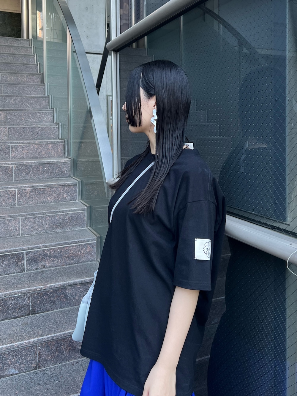 ブラック系のTシャツ/カットソー、ブルー系のスカート、グレー系のショルダーバッグを着用したレディースの夏コーディネートの3枚目の写真