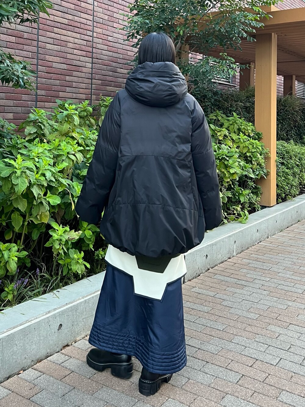 ブラック系のダウンジャケット/コート、その他のスカート、ブラック系のブーツを着用したレディースの秋コーディネートの2枚目の写真