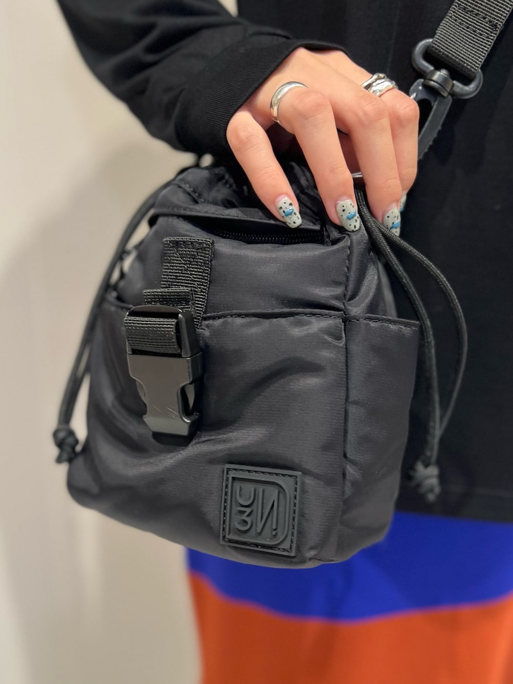 ブラック系のTシャツ/カットソー、ブラック系のショルダーバッグ、ブラック系のブーツを着用したレディースの秋コーディネートの9枚目の写真