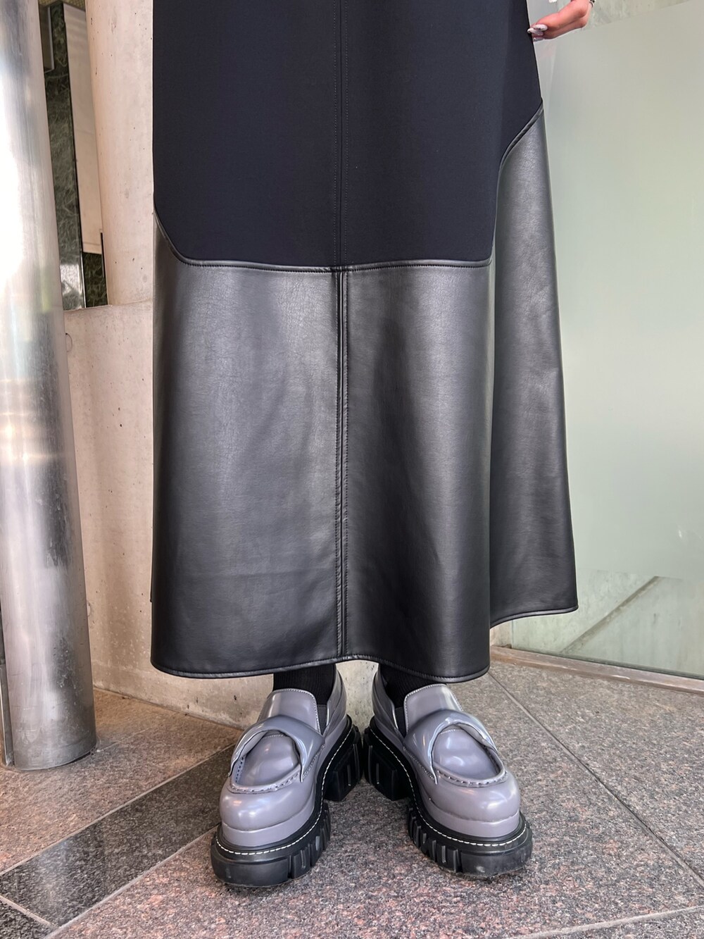 ブラック系のワンピース、グレー系のローファー、レッド系のハンドバッグを着用したレディースの夏コーディネートの5枚目の写真