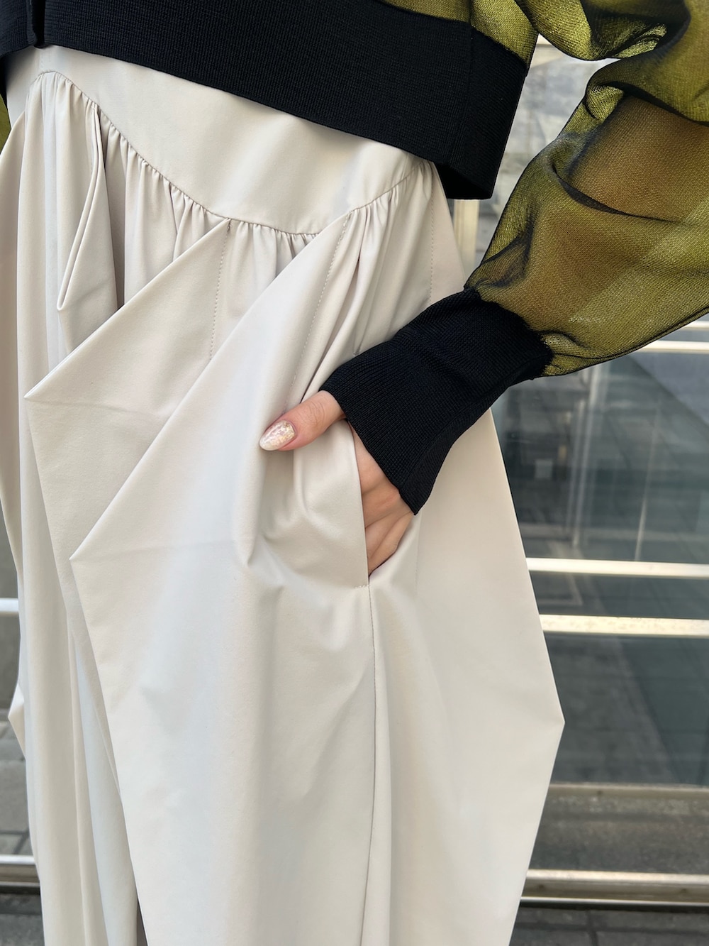 イエロー系のカーディガン/ボレロ、ベージュ系のワンピース、ブラック系のブーツを着用したレディースの冬コーディネートの5枚目の写真