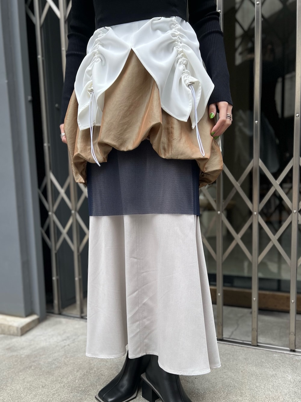 ブラック系のニット/セーター、ホワイト系のタンクトップ、イエロー系のスカートを着用したレディースの春コーディネートの6枚目の写真