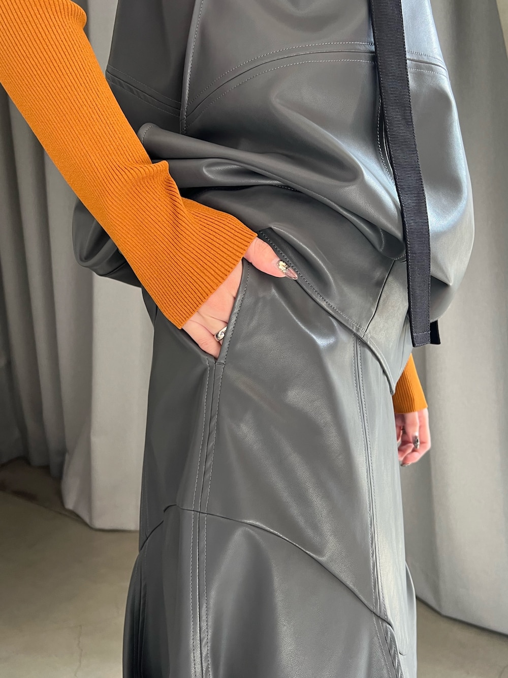 グレー系のその他トップス、グレー系のスカート、ブラック系のブーツを着用したレディースの秋コーディネートの7枚目の写真