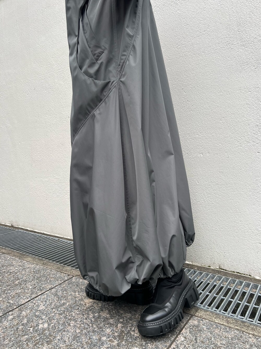 グレー系のワンピース、グレー系のニット/セーター、ブラック系のブーツを着用したレディースの夏コーディネートの9枚目の写真
