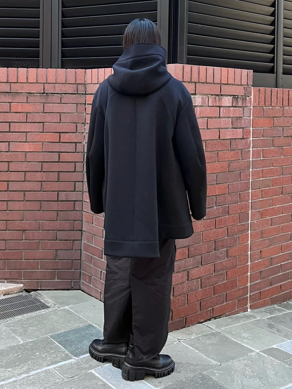 ブラック系のその他アウター、ブラック系のスカート、ブラック系のブーツを着用したレディースの秋コーディネートの2枚目の写真