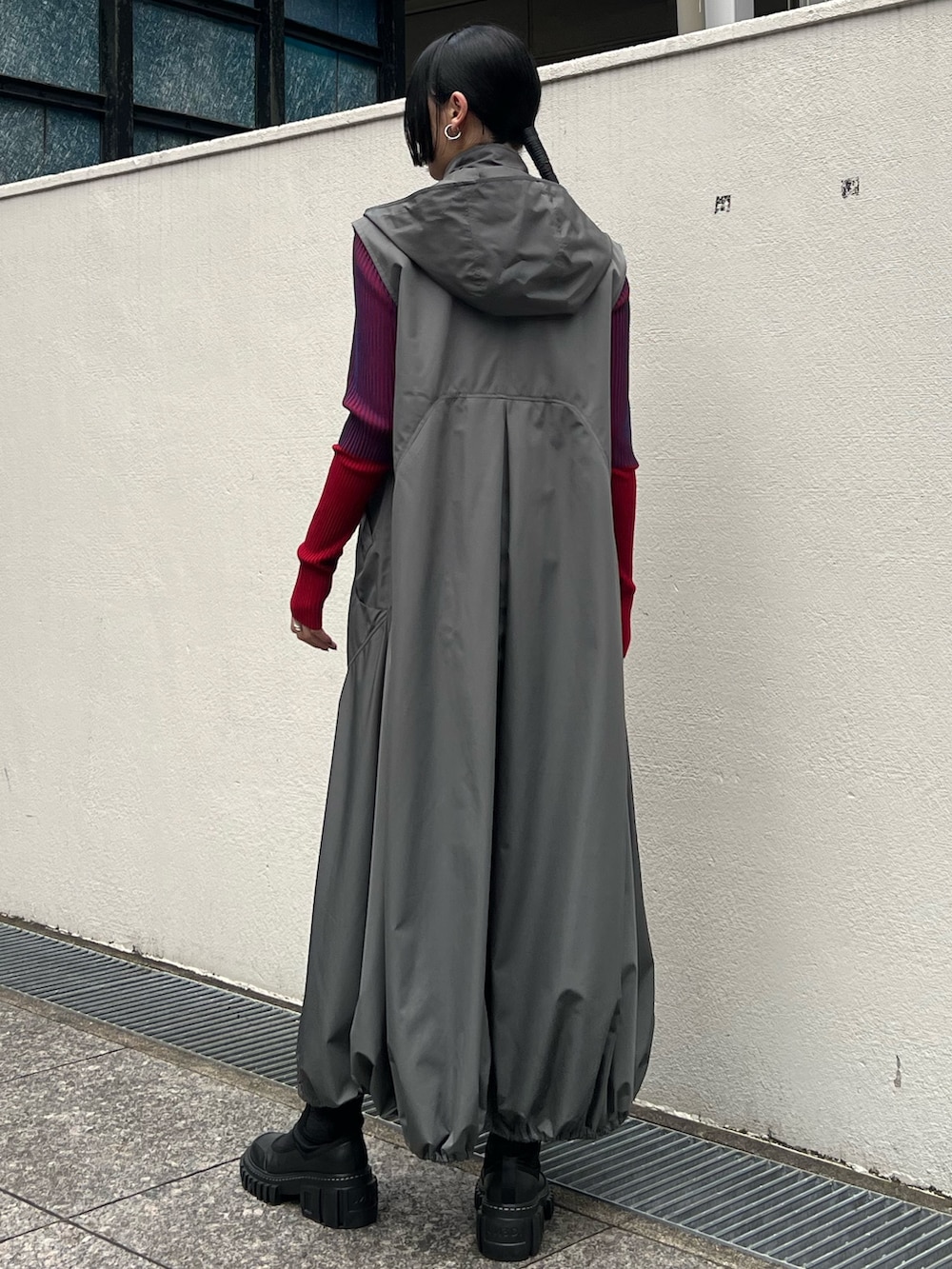 グレー系のワンピース、グレー系のニット/セーター、ブラック系のブーツを着用したレディースの夏コーディネートの3枚目の写真