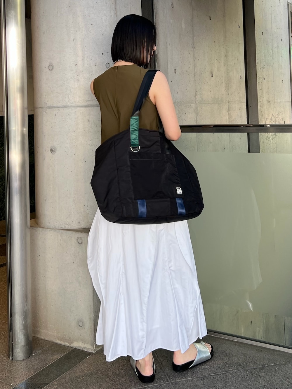 ホワイト系のワンピース、ブラック系のトートバッグ、シルバー系のサンダルを着用したレディースの春コーディネートの2枚目の写真