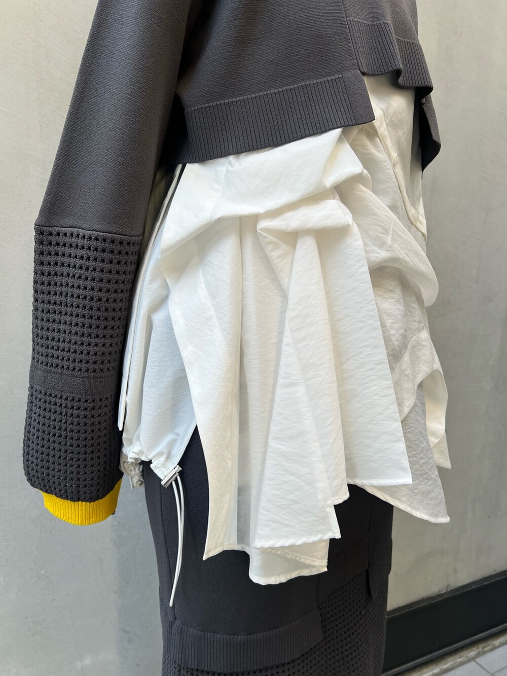 グレー系のその他パンツ、グレー系のニット/セーター、ホワイト系のシャツ/ブラウスを着用したレディースの夏コーディネートの5枚目の写真