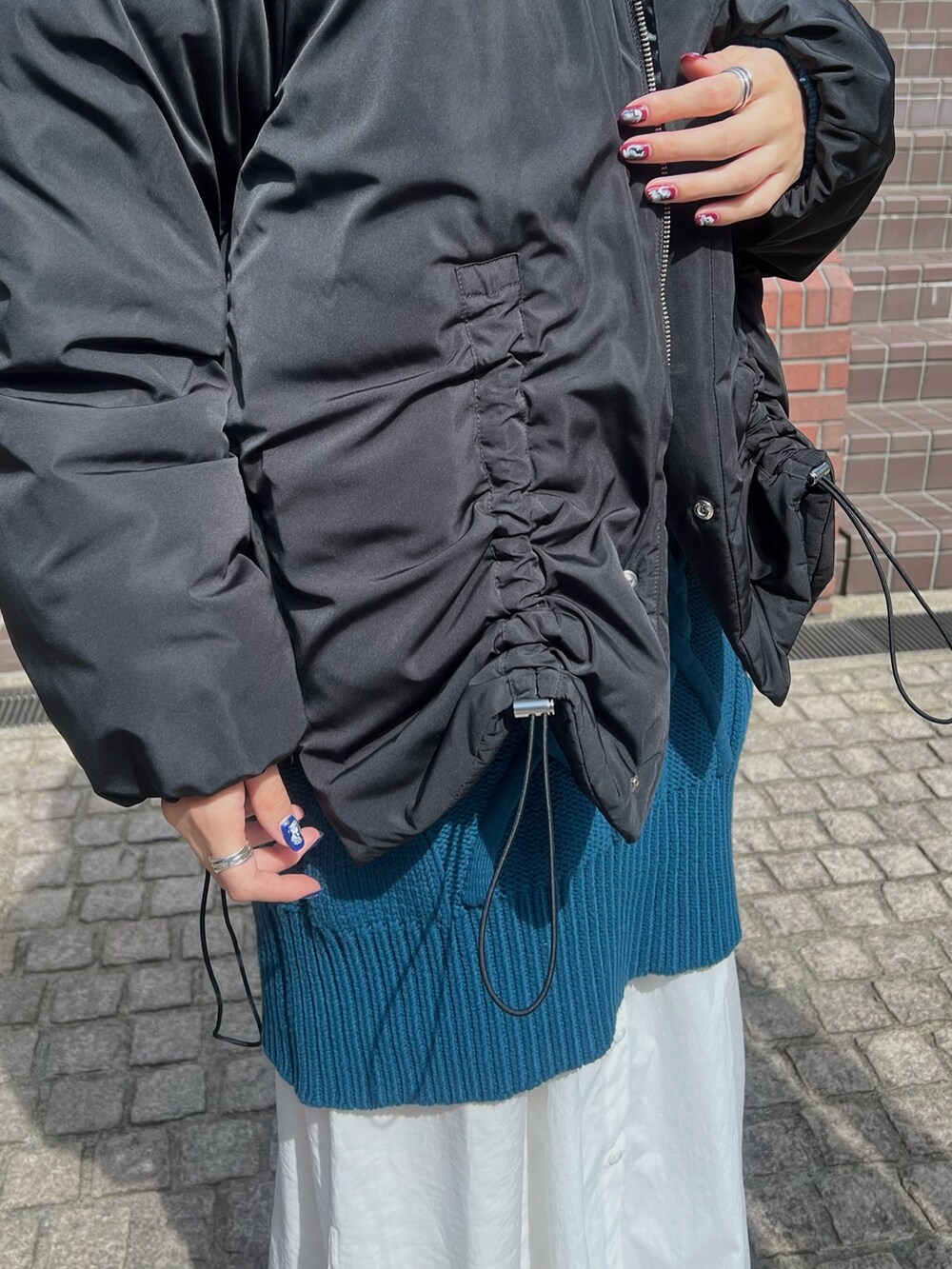 ブラック系のダウンジャケット/コート、ブルー系のワンピース、ブラック系のブーツを着用したレディースの秋コーディネートの4枚目の写真