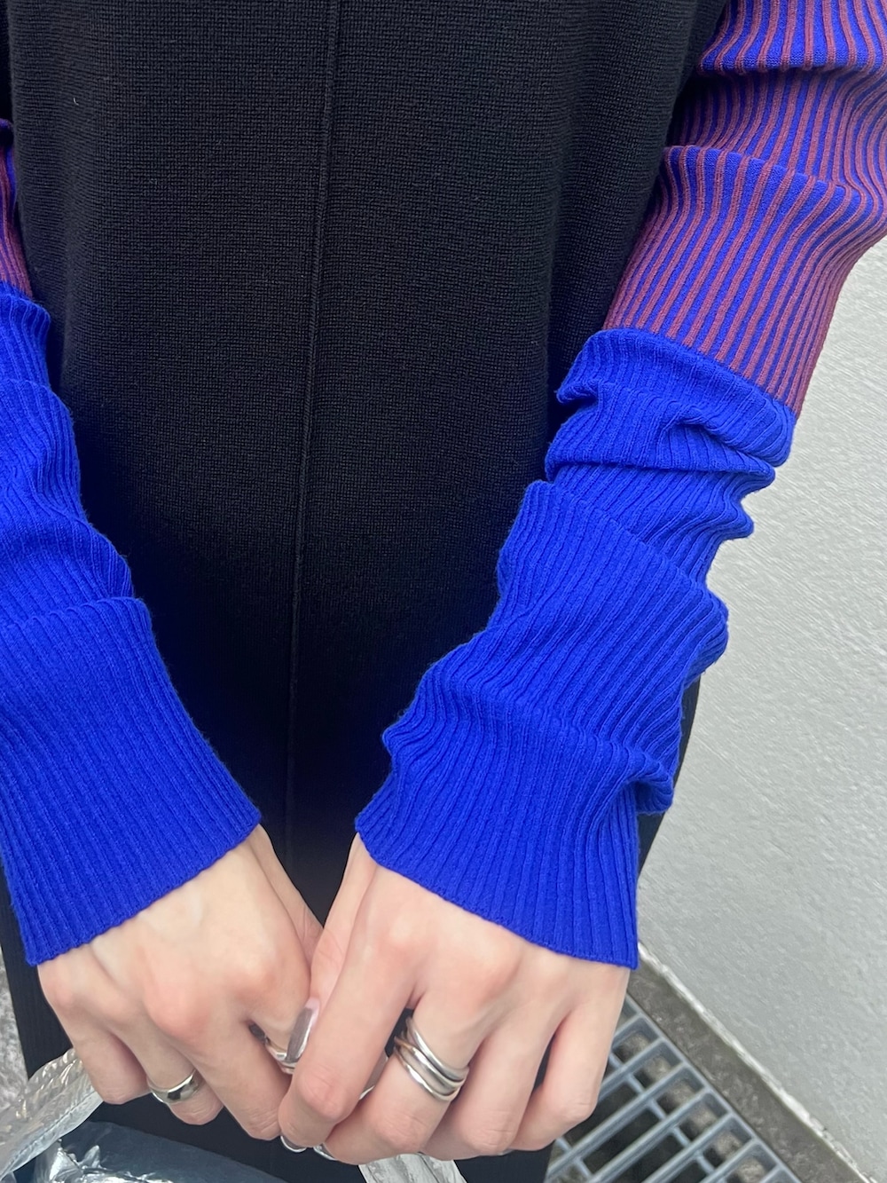 ブラック系のワンピース、シルバー系のハンドバッグ、ブラック系のブーツを着用したレディースの秋コーディネートの5枚目の写真