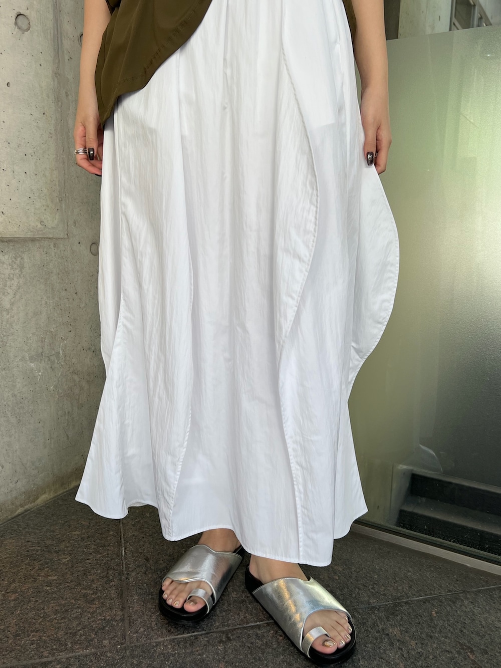 ホワイト系のワンピース、ブラック系のトートバッグ、シルバー系のサンダルを着用したレディースの春コーディネートの7枚目の写真