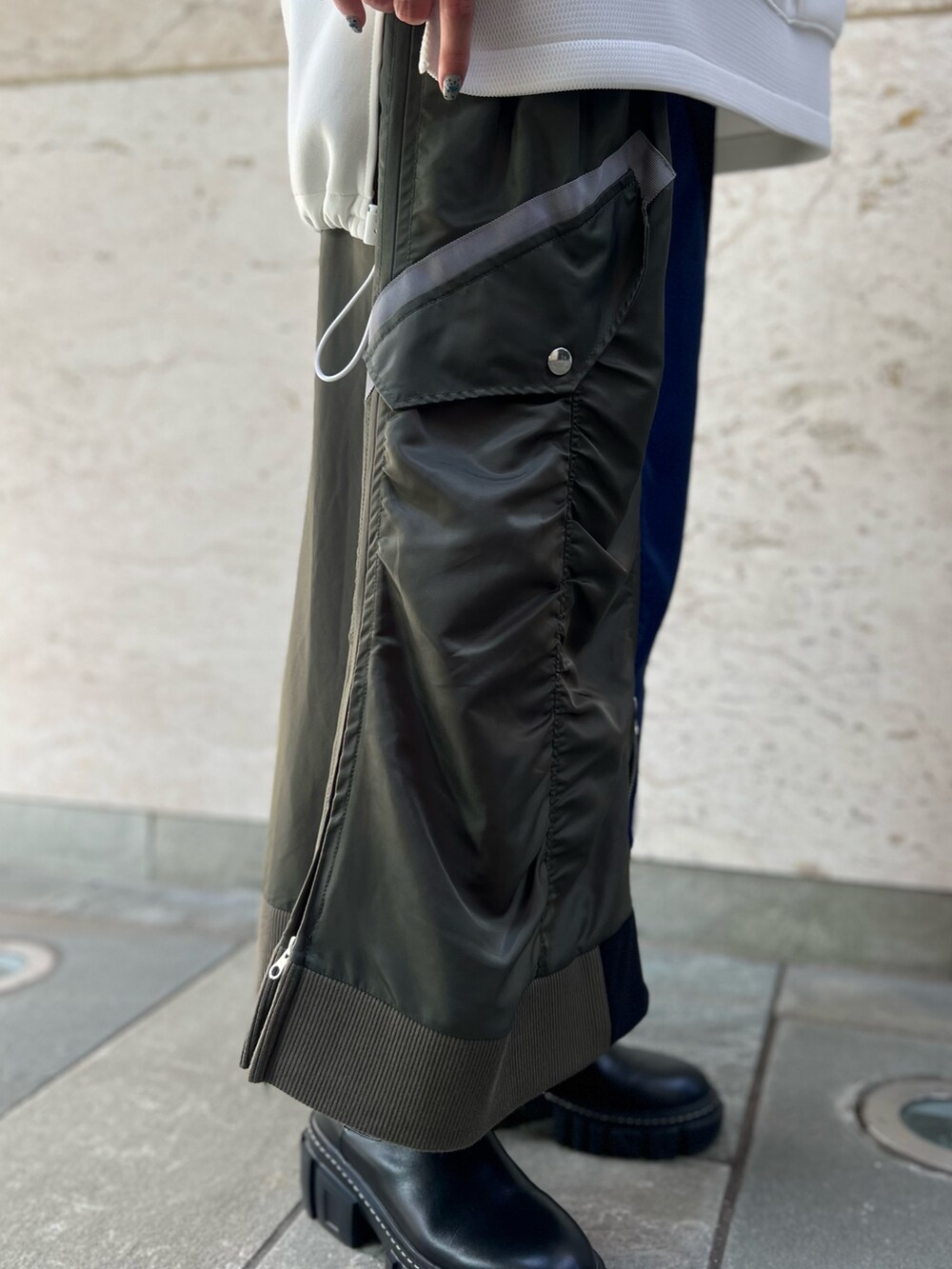 ブラック系のスカート、ホワイト系のスウェット、ブラック系のブーツを着用したレディースの秋コーディネートの10枚目の写真