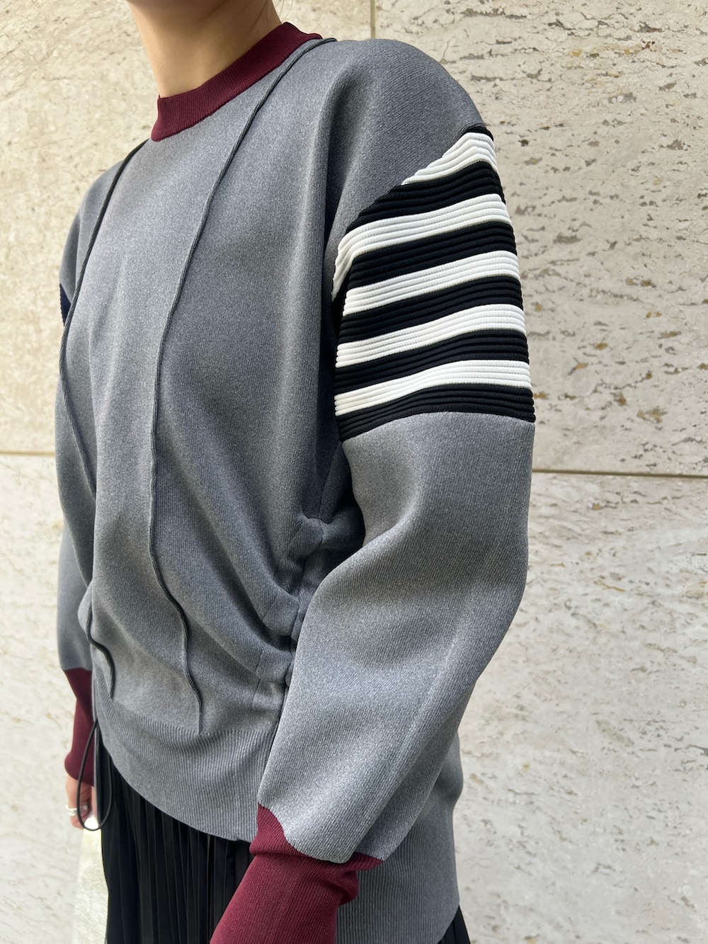 シルバー系のブーツ、ブラック系のスカート、グレー系のニット/セーターを着用したレディースの秋コーディネートの4枚目の写真