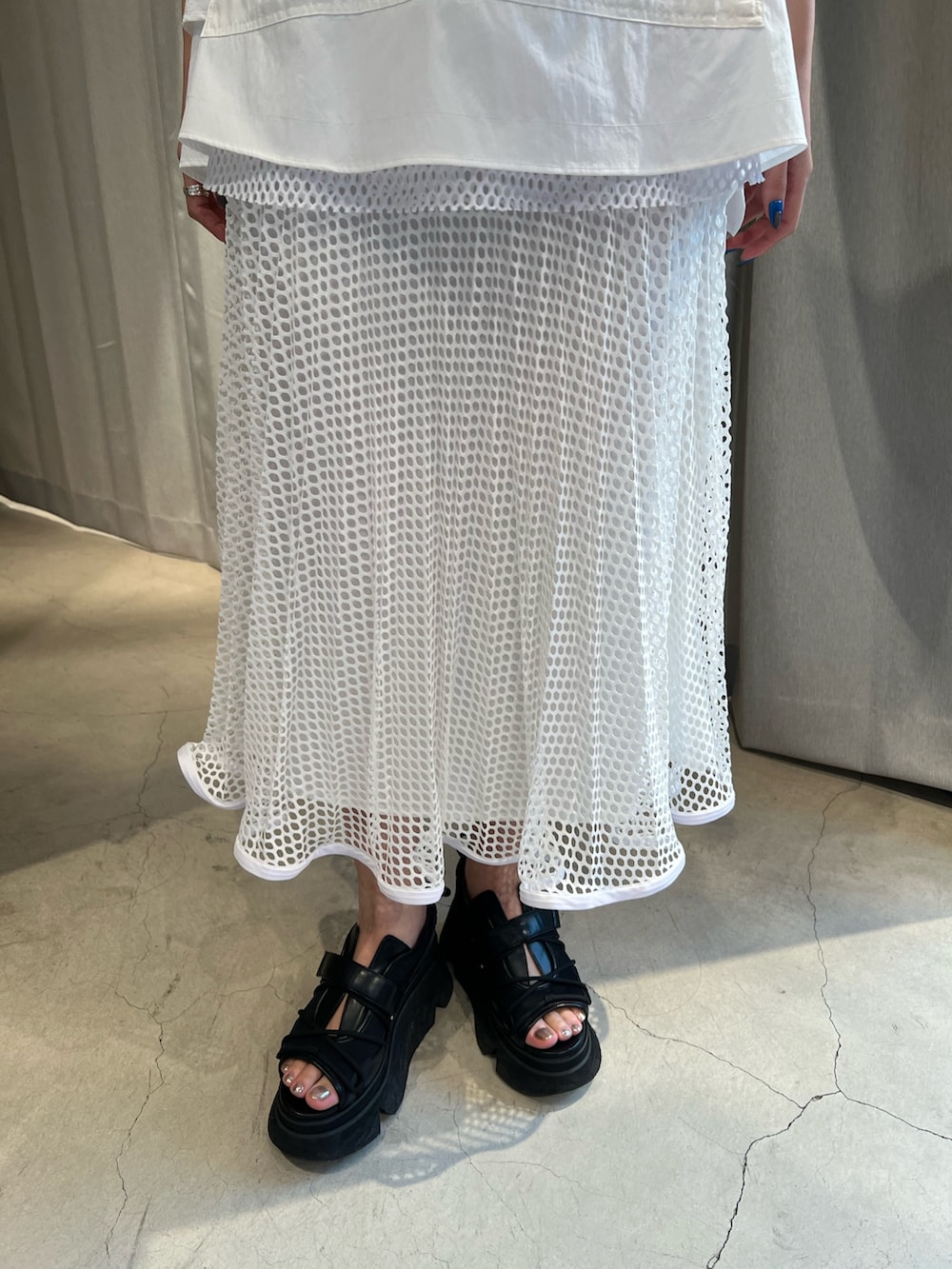 ホワイト系のタンクトップ、ホワイト系のスカート、ブラック系のサンダルを着用したレディースの冬コーディネートの6枚目の写真