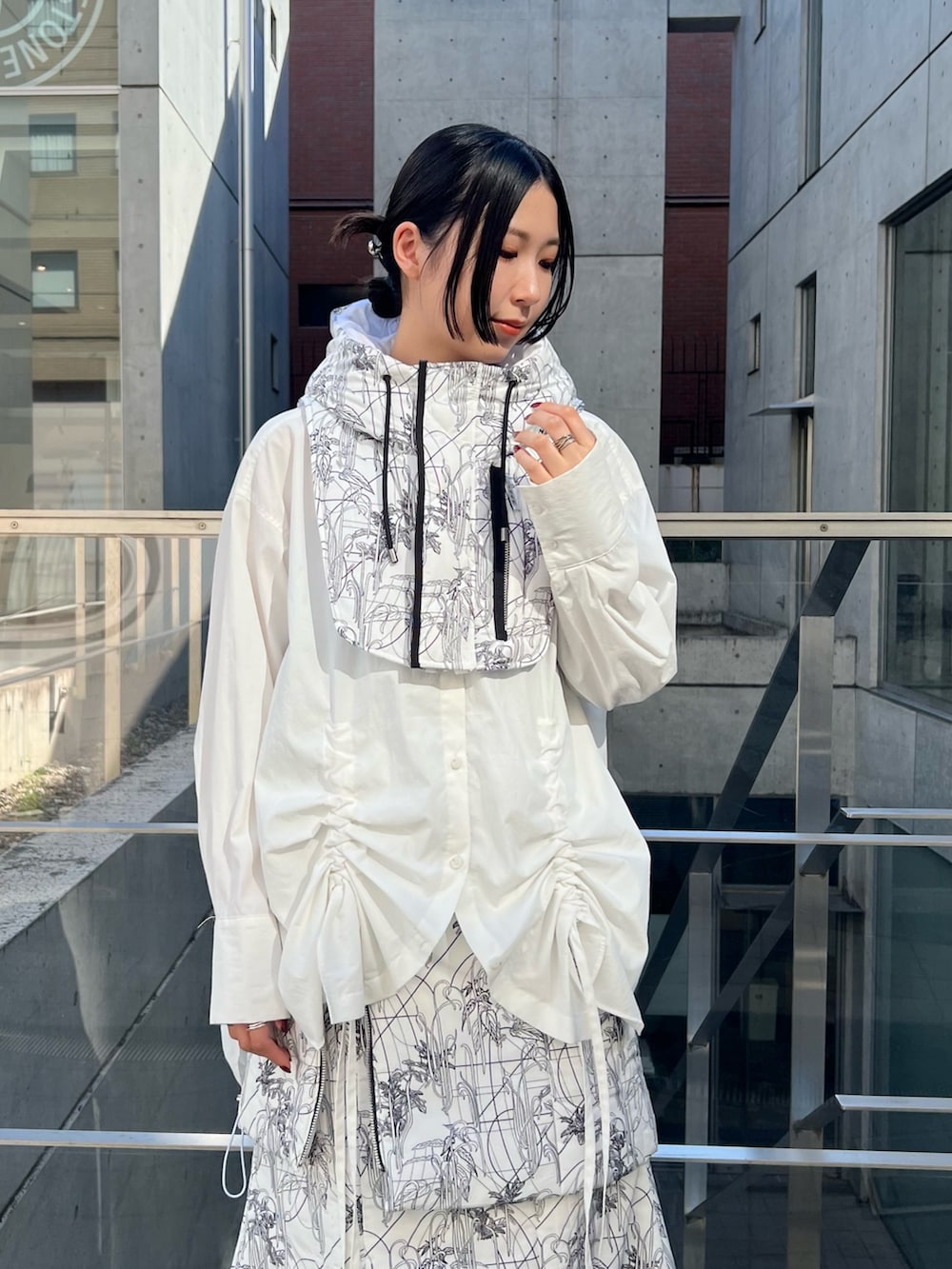 ホワイト系のシャツ/ブラウス、ホワイト系のスカート、ホワイト系のネックウォーマー/スヌードを着用したレディースの秋コーディネートの3枚目の写真