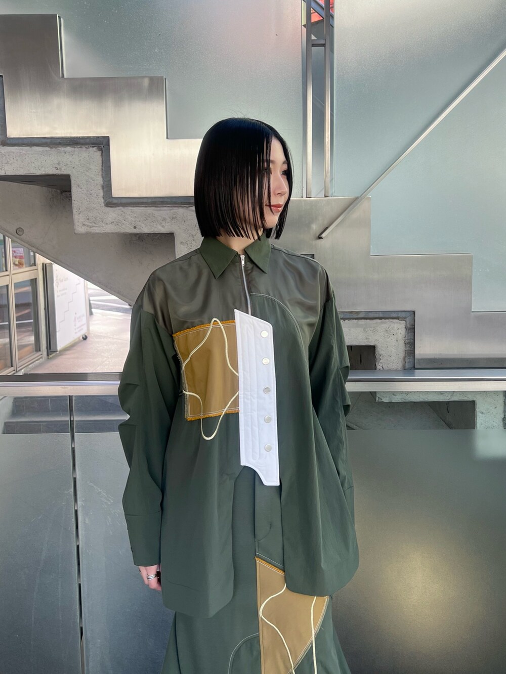 グリーン系のシャツ/ブラウス、グリーン系のスカート、シルバー系のブーツを着用したレディースの冬コーディネートの3枚目の写真