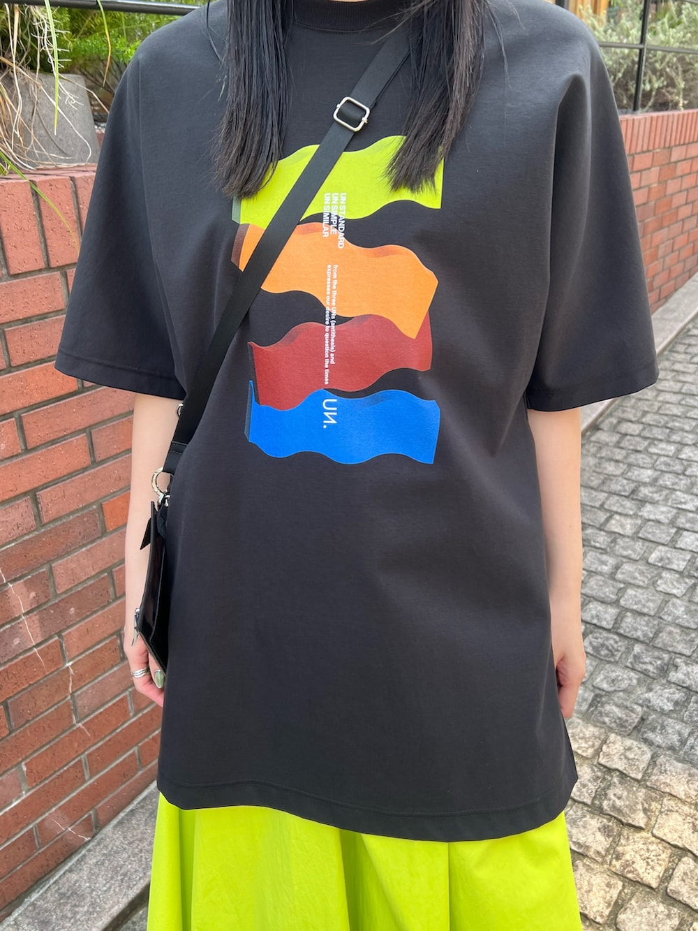 ブラック系のTシャツ/カットソー、イエロー系のその他パンツ、ブラック系のサンダルを着用したレディースの春コーディネートの6枚目の写真