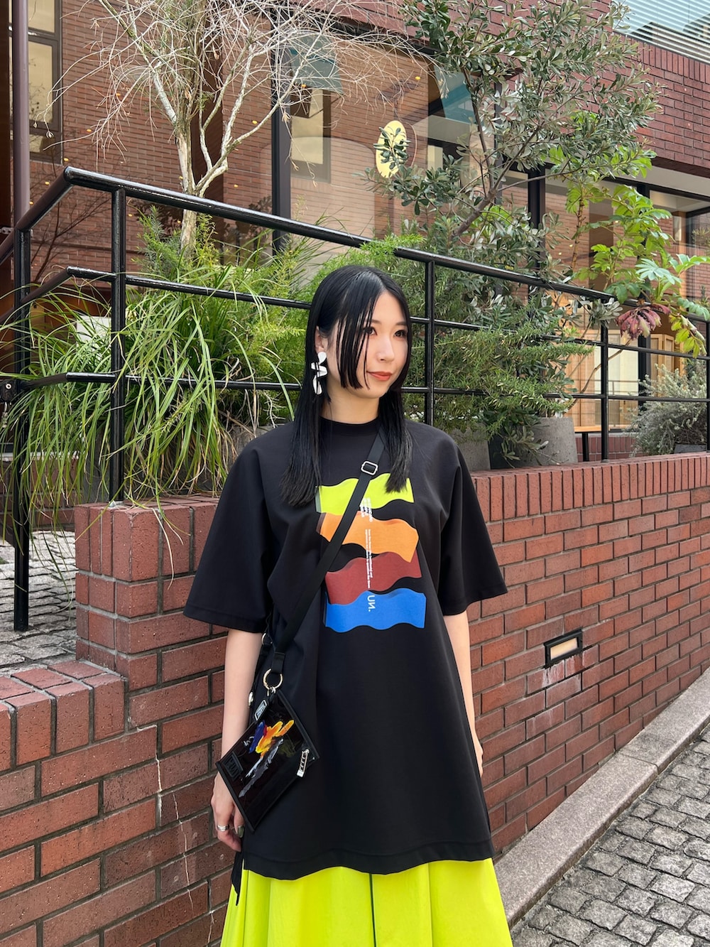 ブラック系のTシャツ/カットソー、イエロー系のその他パンツ、ブラック系のサンダルを着用したレディースの春コーディネートの4枚目の写真