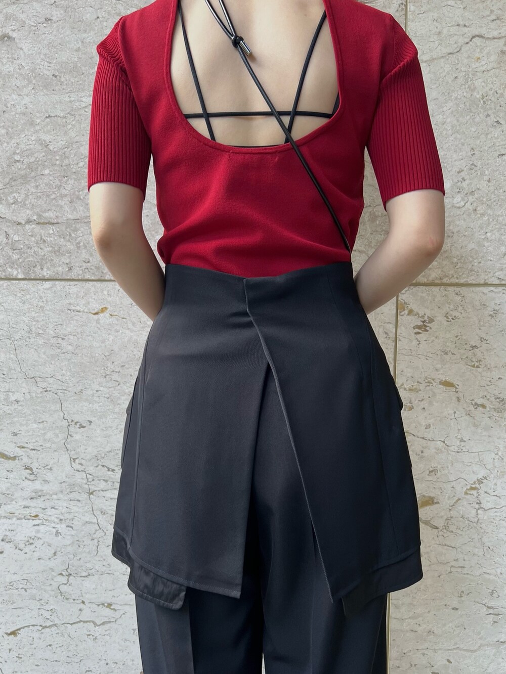 ブラック系のその他パンツ、レッド系のニット/セーター、ブラック系のパンプスを着用したレディースの夏コーディネートの5枚目の写真