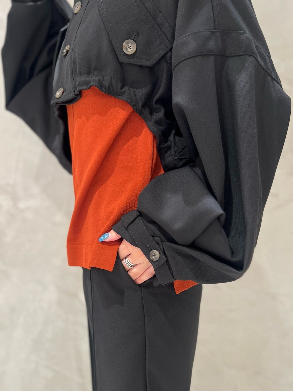 ブラック系のブルゾン、オレンジ系のニット/セーター、ブラック系のその他パンツを着用したレディースの秋コーディネートの7枚目の写真