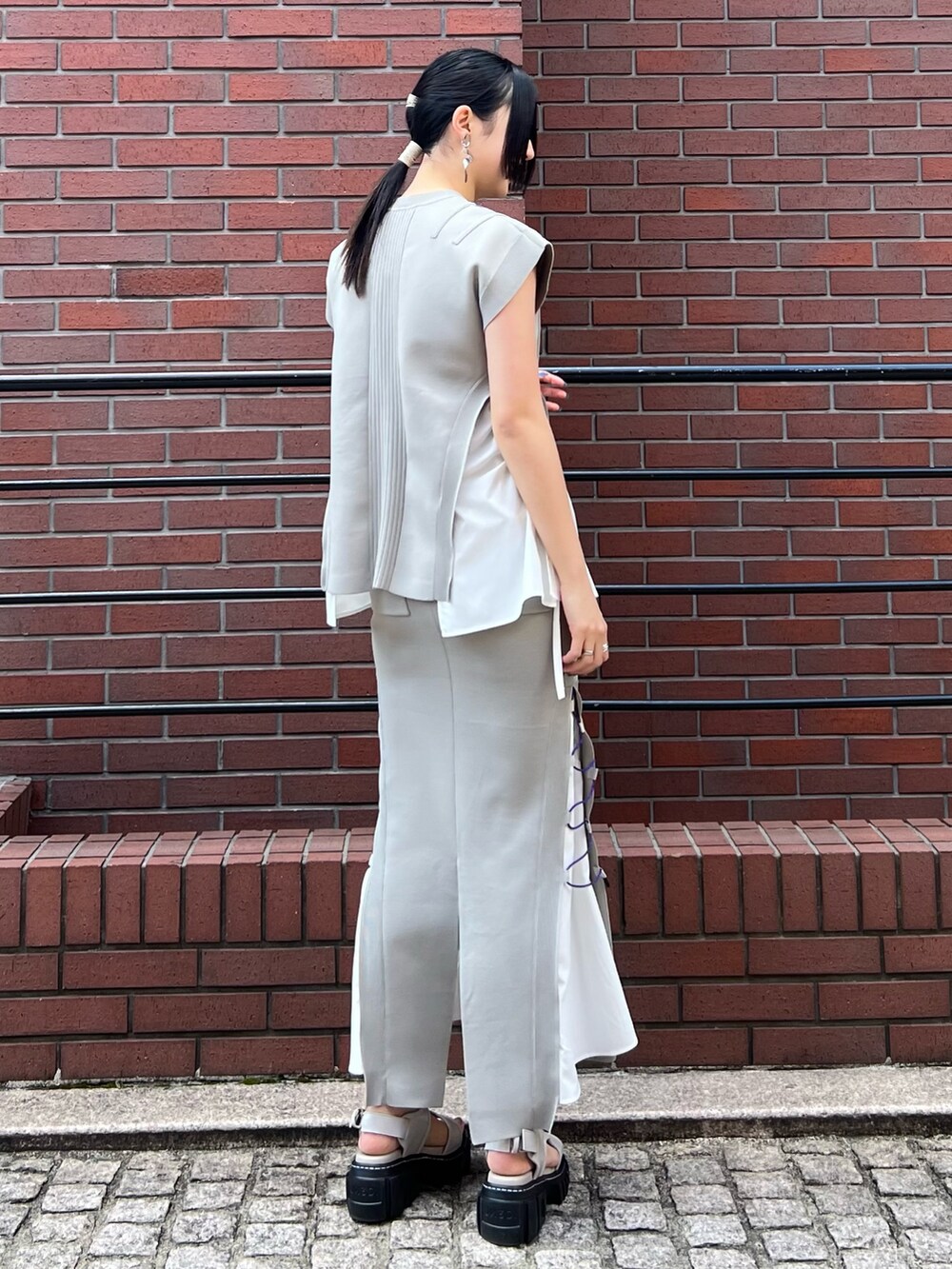 ベージュ系のニット/セーター、ベージュ系のスカート、ベージュ系のサンダルを着用したレディースの春コーディネートの2枚目の写真