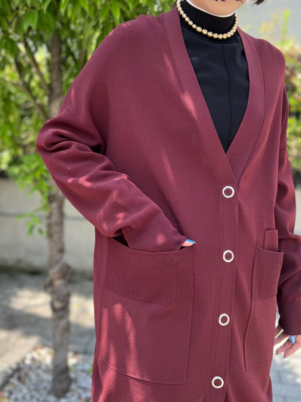 グレー系のスカート、ブラウン系のカーディガン/ボレロ、ブラック系のニット/セーターを着用したレディースの夏コーディネートの4枚目の写真